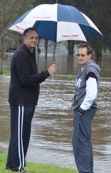 Washed Away: Graham Haley and Allan Rees inspect the rising flood waters on the green.