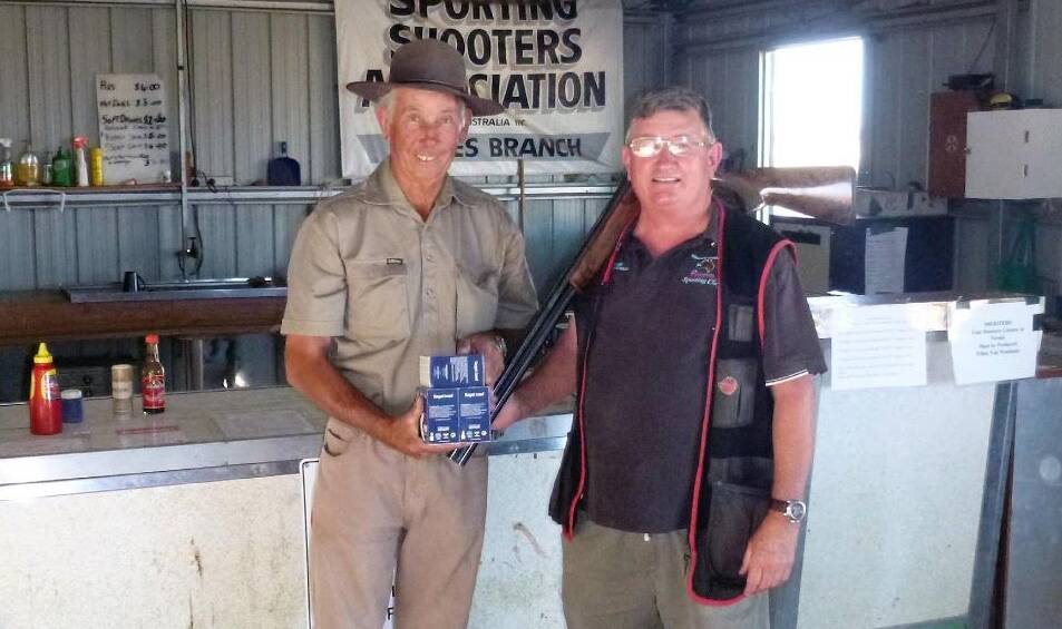 Norm Brook presenting Peter Rea with his prize after winning the A grade 100 target field shoot.