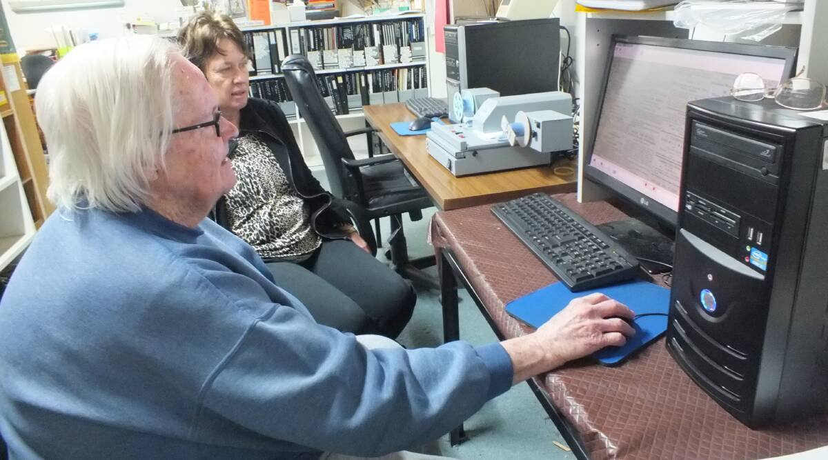 Kim Smith and Bernie Symons use the new film and fiche reader at the Forbes Family History Group research room.