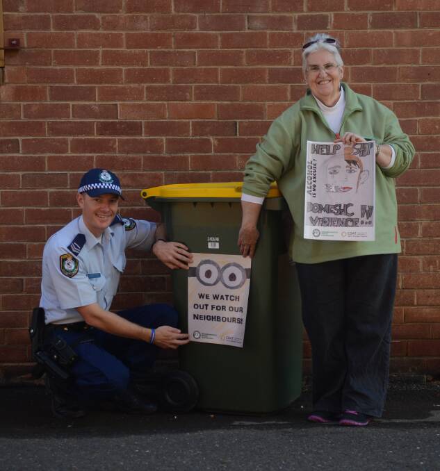 Senior Constable Daniel Greef and NHW President Lyn Ward with the bin stickers. 