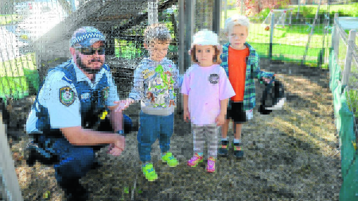 Constable Guy Battin with disappointed and confused pre schoolers Matthew Wallace, Amelia Grayson and Lennox Hurford. 0415preschoolhens(2)
