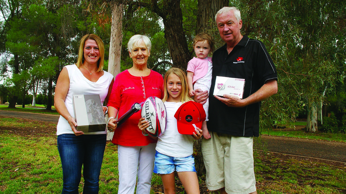 Ashley, Monica and Maddie Sanderson and Robert McKeown, holding his granddaughter Lottie Quirk, with just a few of the items donated by local businesses to today’s Greg Sanderson Memorial Golf Day. 0315sanderson