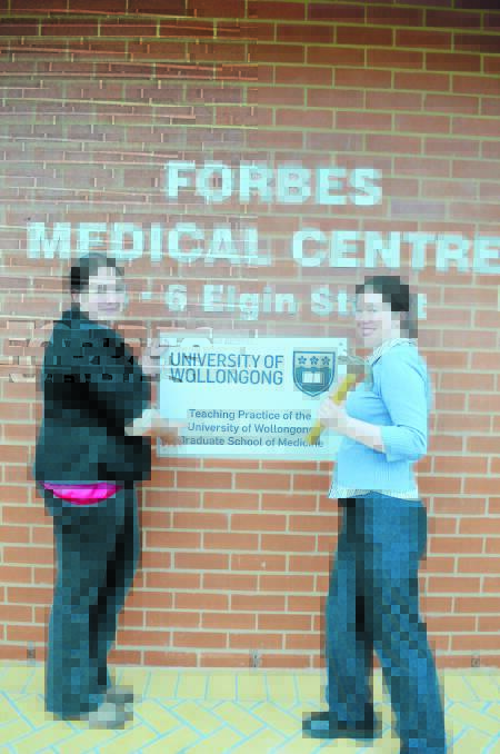 Hayley Dyke and Rebecca Devitt’s first task at the Forbes Medical Centre was to put their surgical skills into erecting the University of Wollongong’s plaque. 0714Nnewstudents (5)