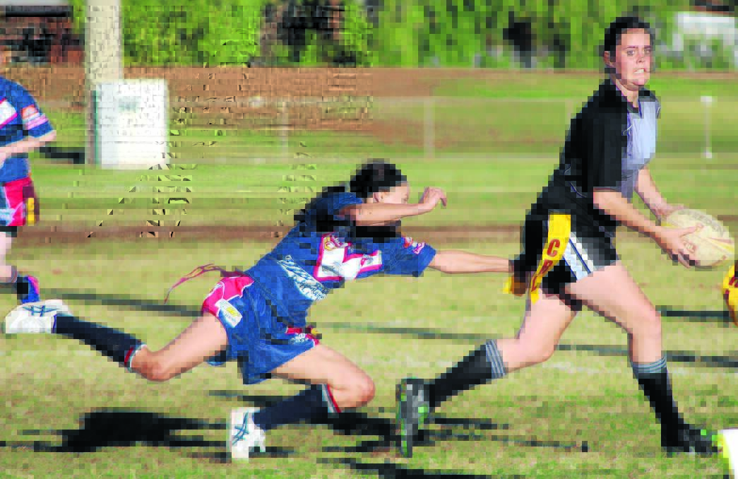 Forbes ­Magpies league tag player Laikan Brennan (with ball) attempts to evade Cobar’s Lisa Travis last weekend. The Forbes women won the game 24-16.
