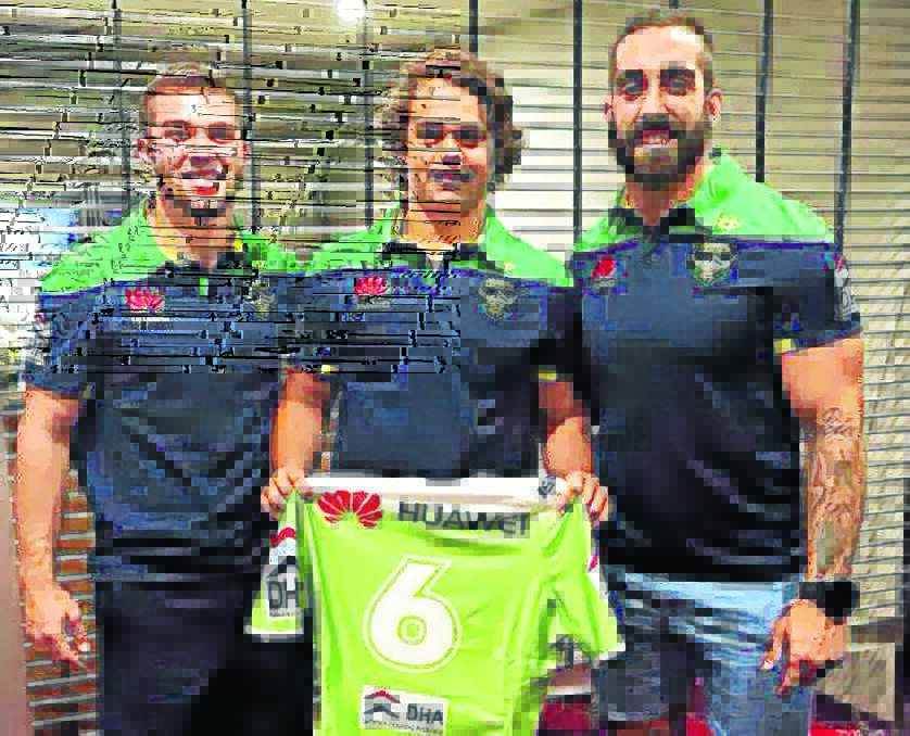 Mitch Cornish and Paul Vaughan present Bailey Hartwig (middle) with his jersey.