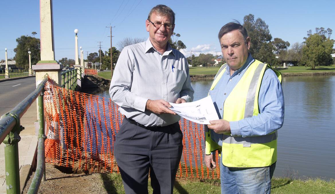 Forbes Shire Council’s general manager Brian Steffen and Transbridge Group manager Adrian Mansley look over plans for the new bridge to be built adjacent to Camp Street bridge. Work started on the project last week. 0613bridgework (1)