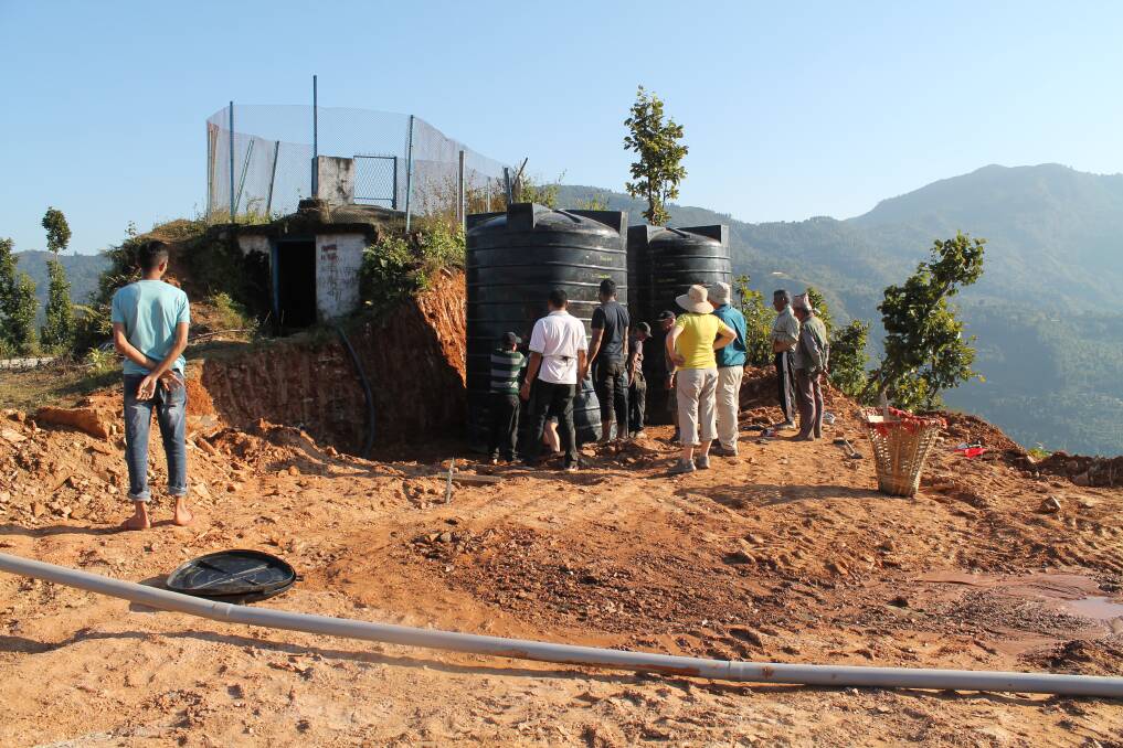 The team installs water tanks in the village. Picture supplied