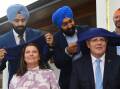 Prime Minister Scott Morrison and wife Jenny get their headscarves at Perth Sikh Gurdwara. Picture: AAP
