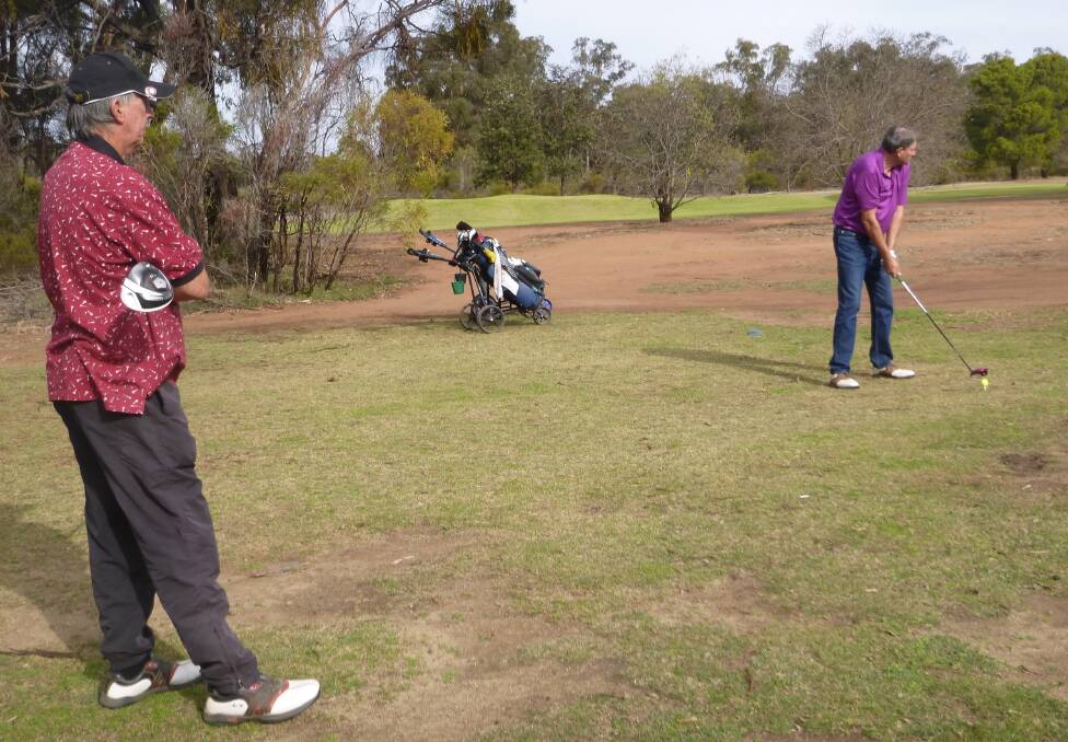 On Target: Ian Bown teeing off on the 17th watched by West Wyalong player Ray Cartwright.