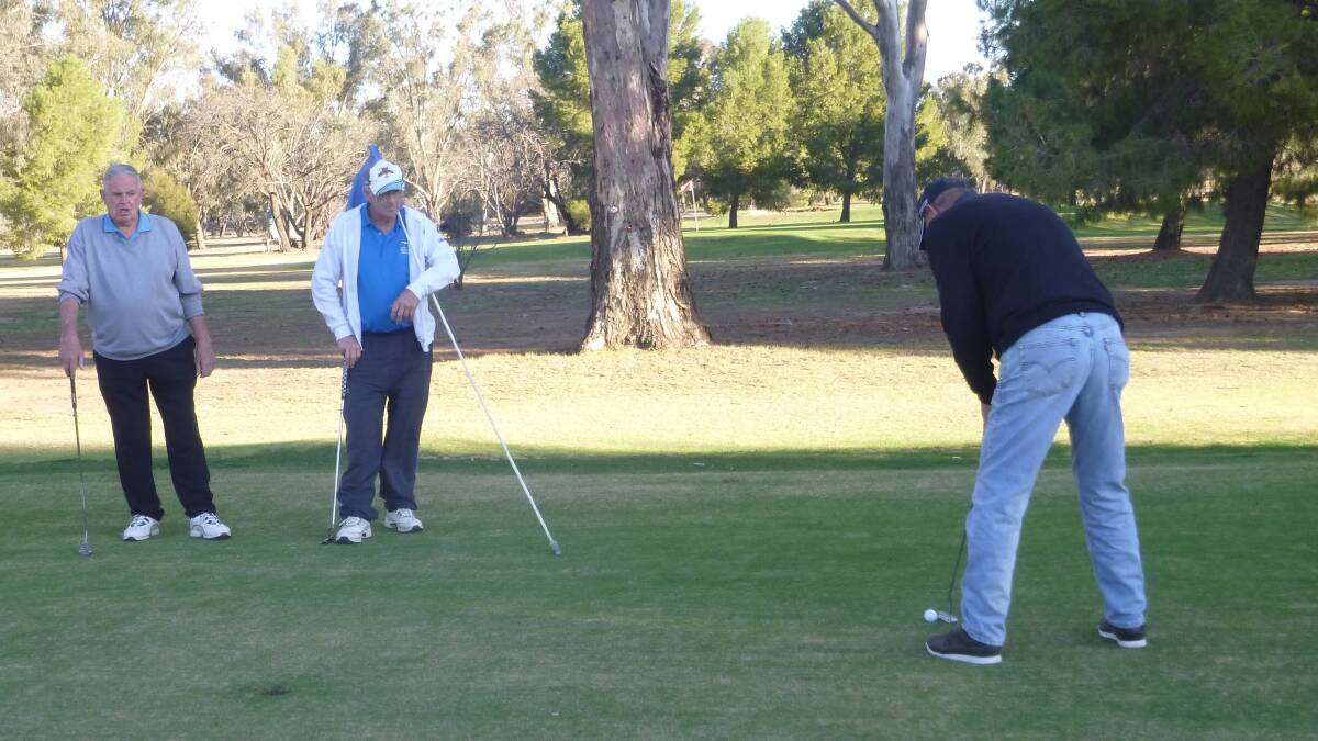So Focused: Rod Besgrove and Bruce Chandler watch as Geoff Drane concentrates on his par putt.