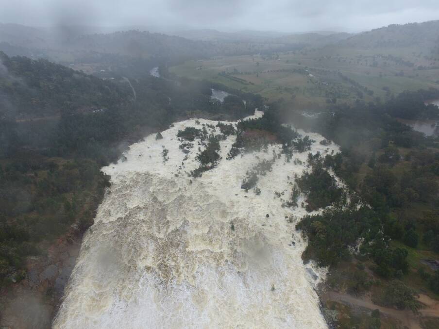 HERE SHE COMES: Wyangala Dam spilling at 104.9 per cent and a rate of up to 80GL a day on Saturday. As you can see, it was still raining at the time. Picture: Craig Dwyer