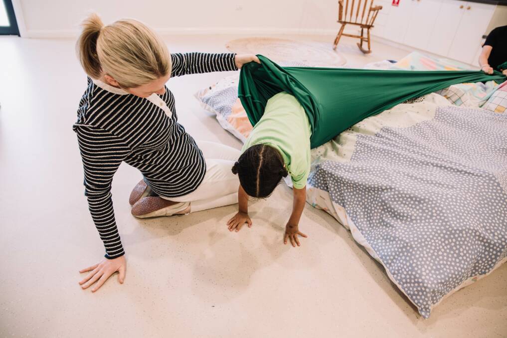 Crawling is a critical sensory motor milestone and occupational therapist Sarah is encouraging crawling through the tunnel at Forbes Preschool. 