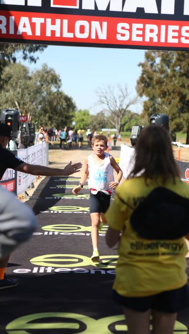 A young entrant gets a high five as he crosses the finish line in the 2017 triathlon.
