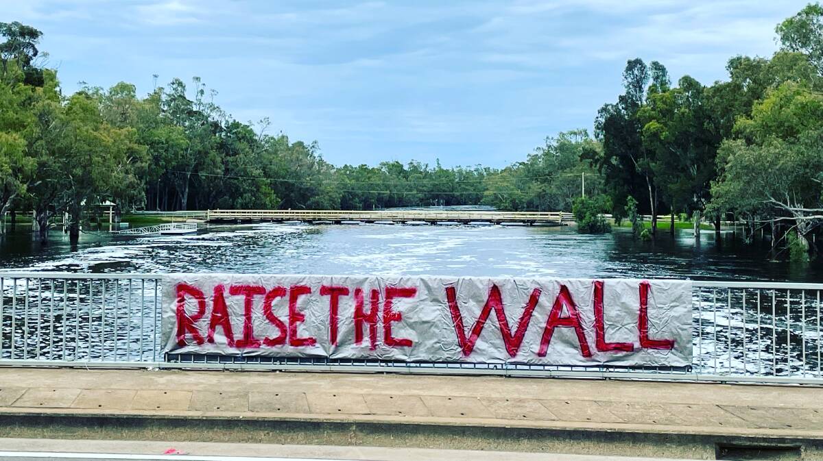 ICYMI: A second RAISE THE WALL has been put up on the bridge over the swollen Lake Forbes on Saturday. Picture: Susie Williams-Green