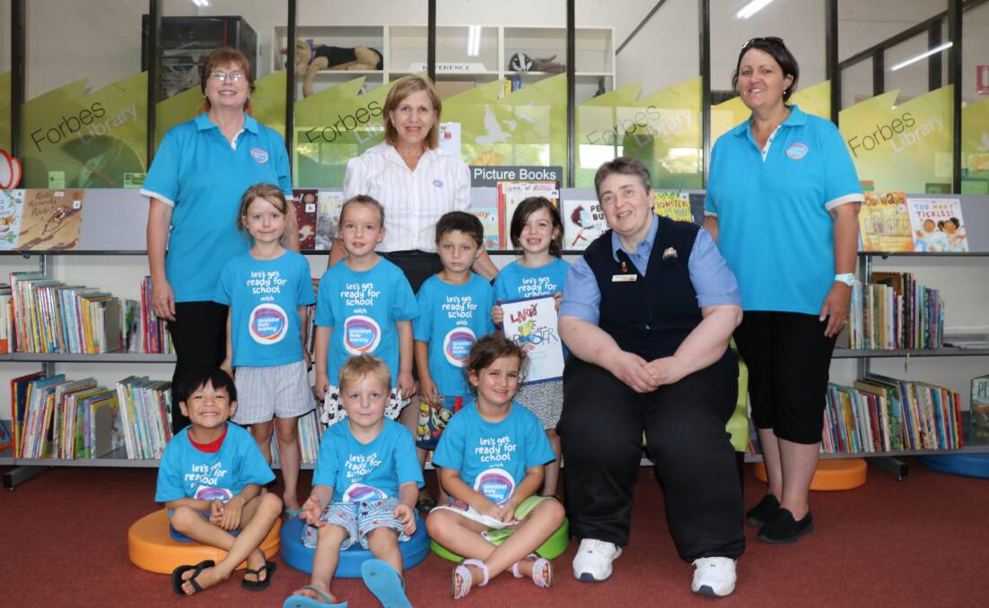 Goodstart's Kay Myors, Vickie Spencer and Julie Riley with Holly Maslin, Abriella Johnson, Jaxon Gilchrist, Lexi Millerd presenting the book to librarian Bronwyn Clark and (front) Jayden Tran, Tayte Bell and Willow Nunn. 
