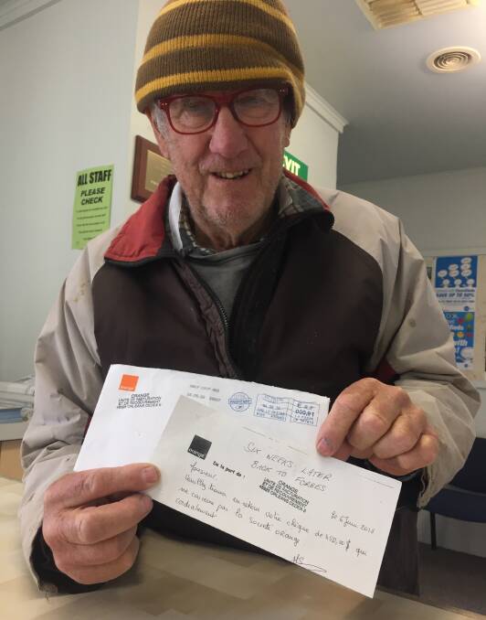 Ian Taylor with the French-postmarked envelope and note that came back with his cheque. 
