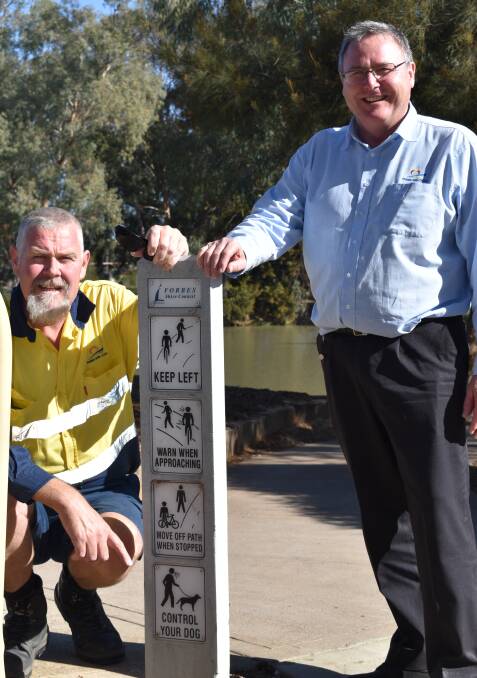 Ranger Mathew Wallis and Director Paul Bennett with one of the signs reminding people to keep their dogs on leads. 
