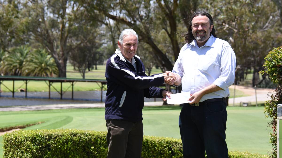 Golf club captain Steve Grallelis presents the charity day proceeds to Dane Millerd from Currajong Disability Services.