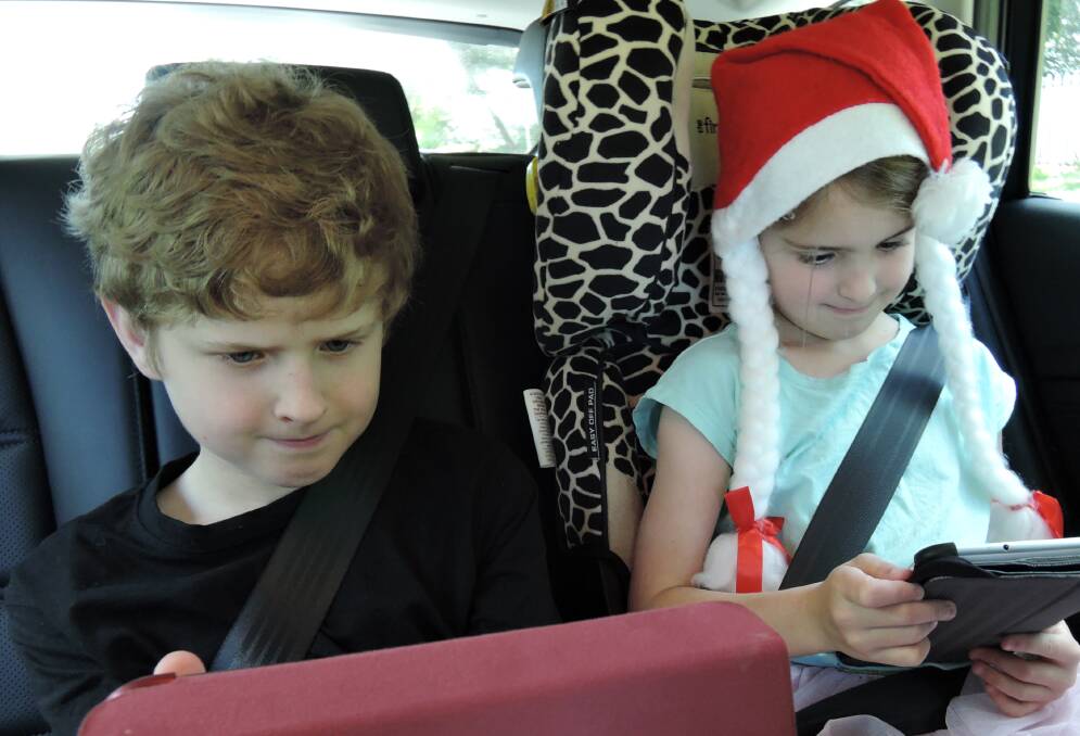 Owen and Addalyn fully occupied in the car. 