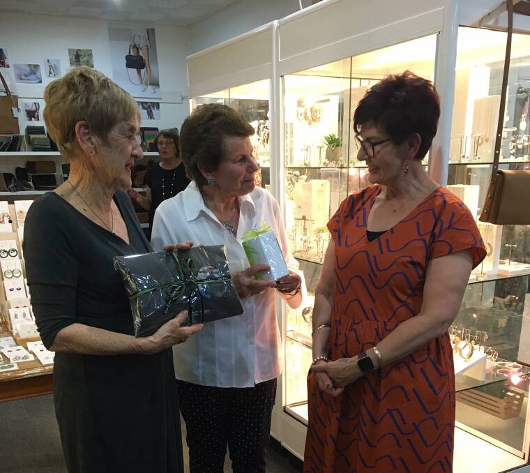 Esther Hyde and Wendy Drady receive their lucky door prizes from Leigh Bartholomew.
