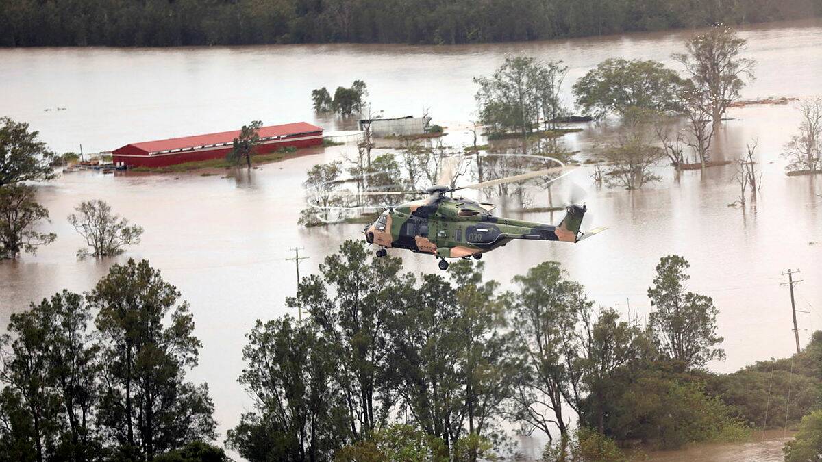 An Australian Army MRH-90 Taipan helicopter flies over flood-affected properties in the Ballina region of New South Wales as part of Operation Flood Assist 2022. Photo: Capt C Barnett.
