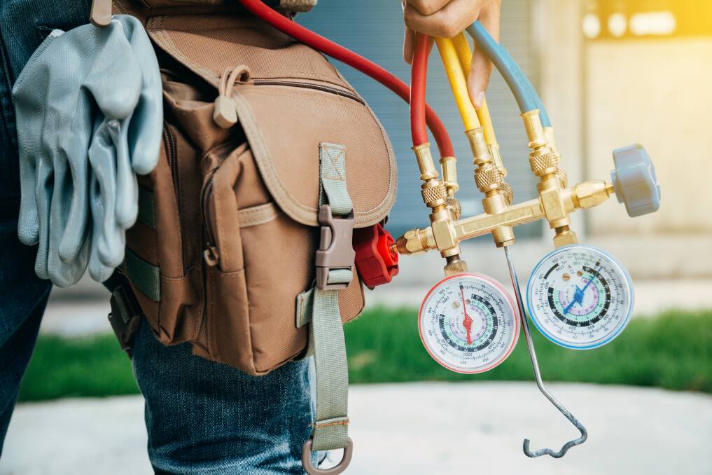 ON THE JOB: A refrigeration technician will check the gas charge in an air conditioner as part of a regular service. Photo: Shutterstock