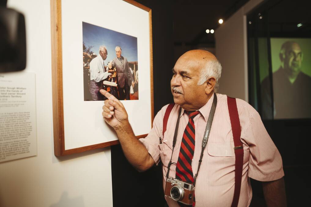 Photographer Mervyn Bishop at the National Film and Sound Archive of Australia with the photo he took of then-prime minister Gough Whitlam and Vincent Lingiari. Picture: Dion Georgopoulos