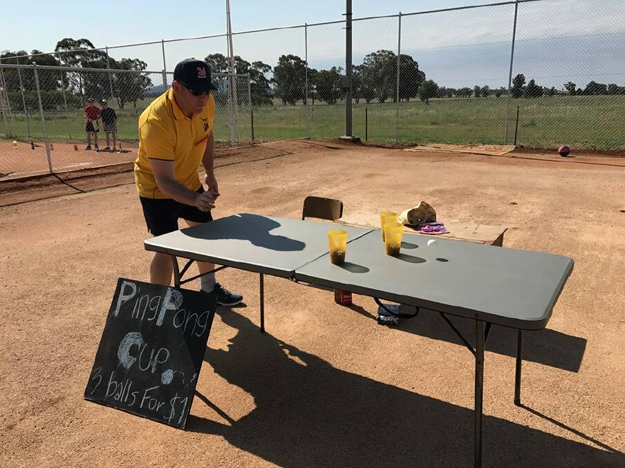 Philip Donato tries his hand at the Wirrinya Annual Picnic Day ping pong cup challenge.