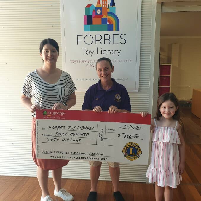 Forbes Toy Library President Amy Smith and Phoebe Smith (right) accept a cheque from Forbes Lions Club's Lanelle Dukes-Rankmore.