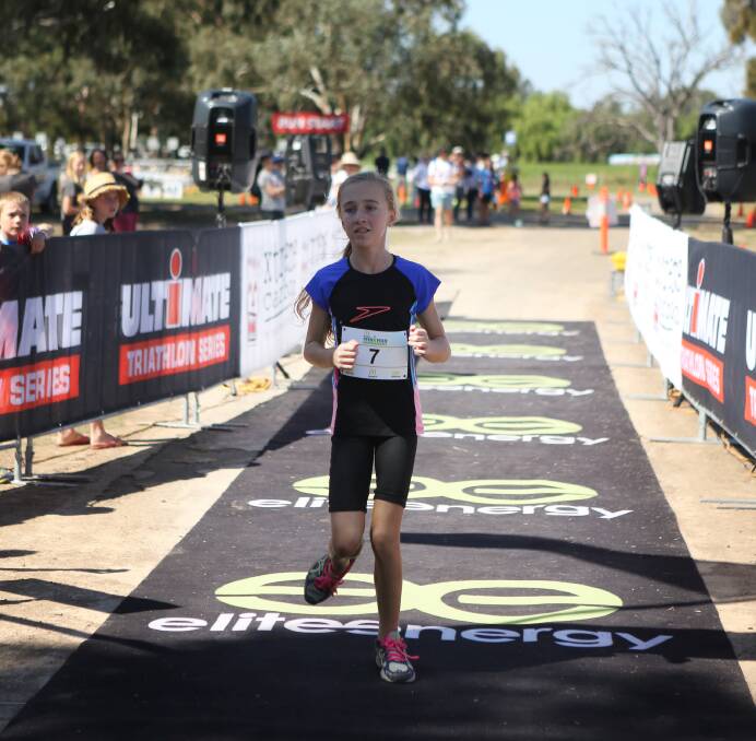 A young entrant crosses the finish line in 2017 triathlon.