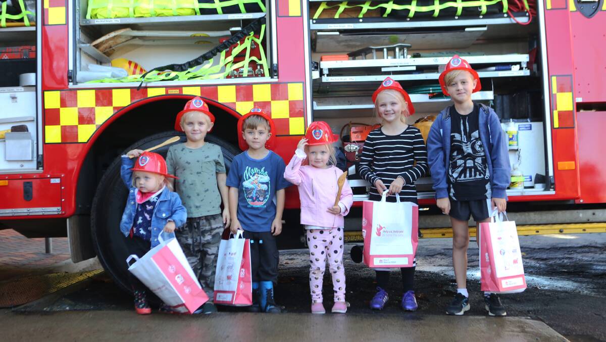 Maddy and Bobby Male, Jake Cheney, Millie and Bella Male and Will Cheney with their firefighter hats and goody bags at last year's fire station open day.