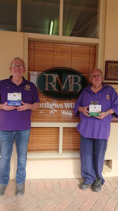 Lions members Ian Acret and Neil Lambert dropping off some of their Christmas cakes and puddings at RMB Matthews Williams Lawyers. Photo supplied.