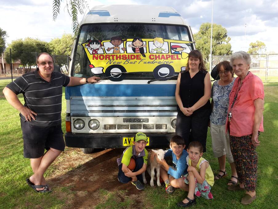 Rex and Rachel Taylor, Nina Huppatz, Coral Helwig and (front) Josiah, Philip and Naomi Klingner with a poddy lamb and the old bus. 