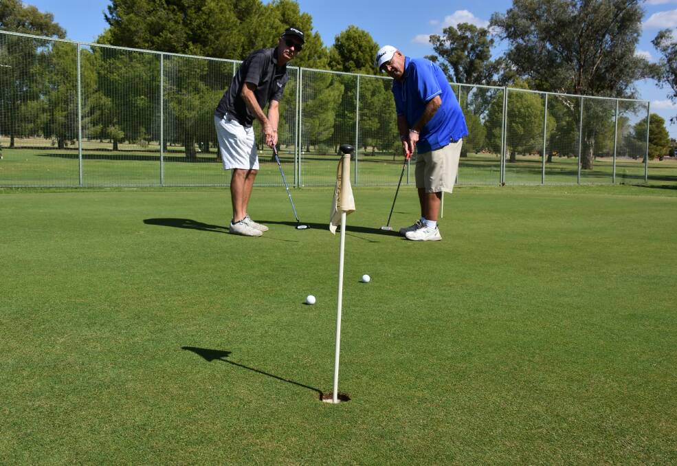 Alf Davis and Ray Taylor practising their short game in preperation for the Forbes Veterans Week of Golf.