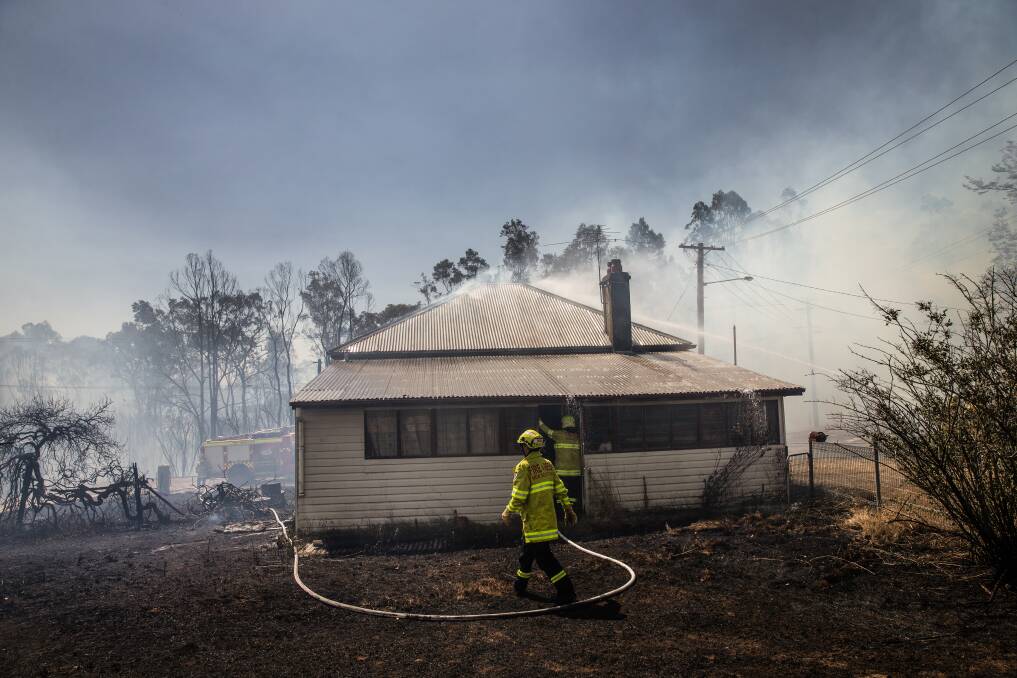 RESPONSE: Fire crews protect a property at North Rothbury on Tuesday. Picture: Marina Neil